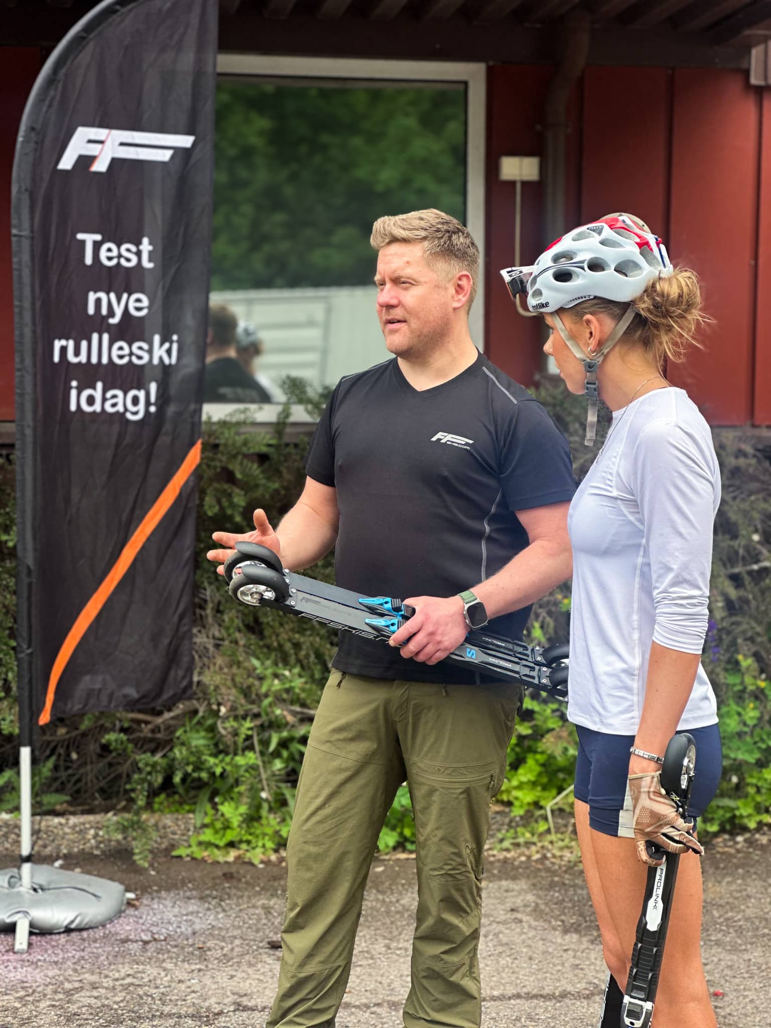 Henrik and Iselin standing outside with roller skis.